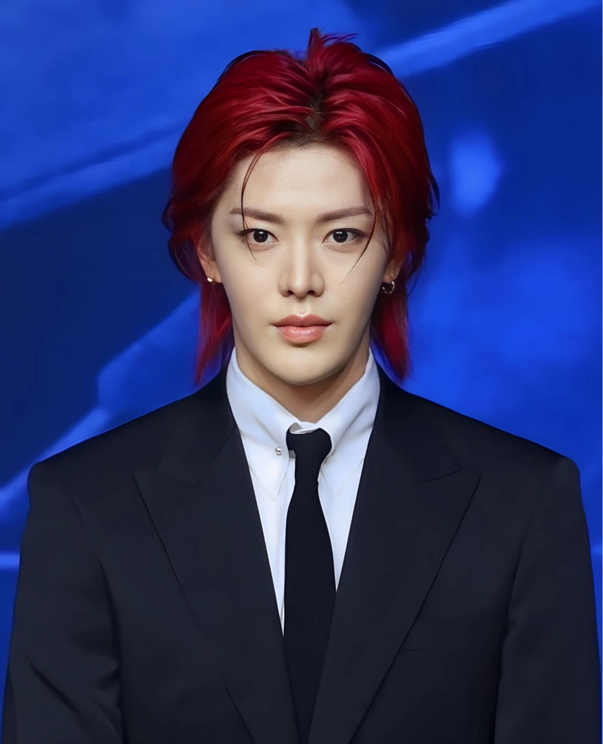 Yuta Nakamoto in a black suit against a blue background
