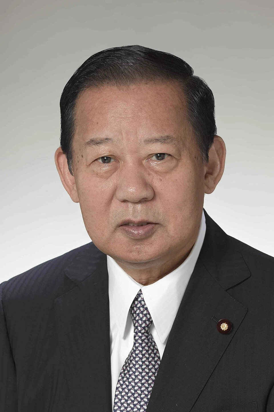 Portrait of Toshihiro Nikai in a suit and tie